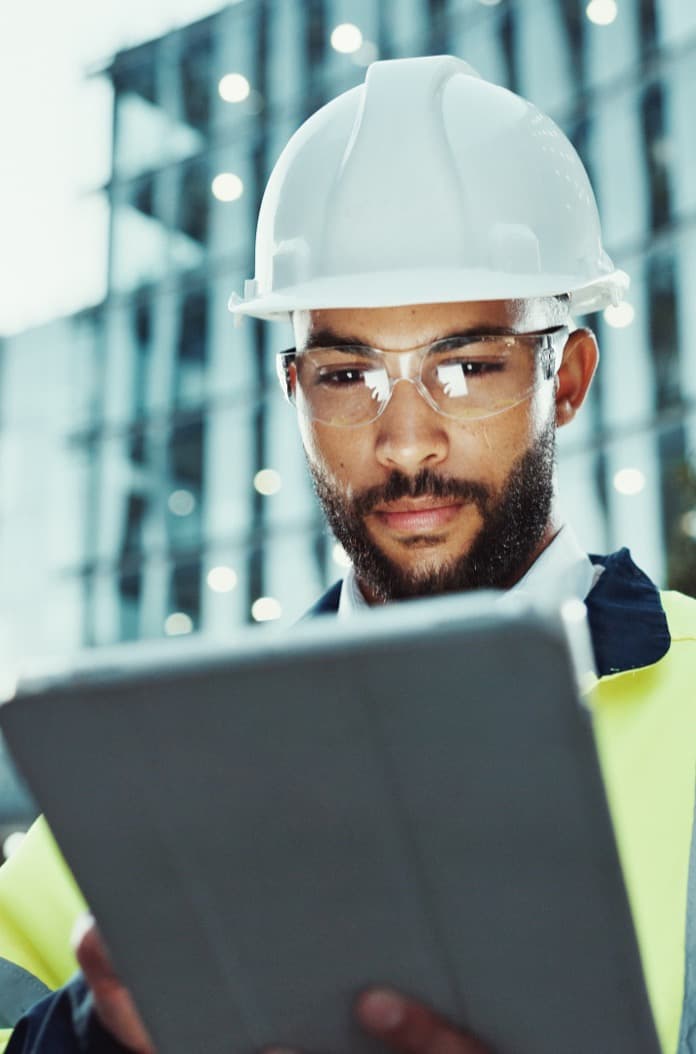 Civil engineer holding a tablet with the city skyline behind