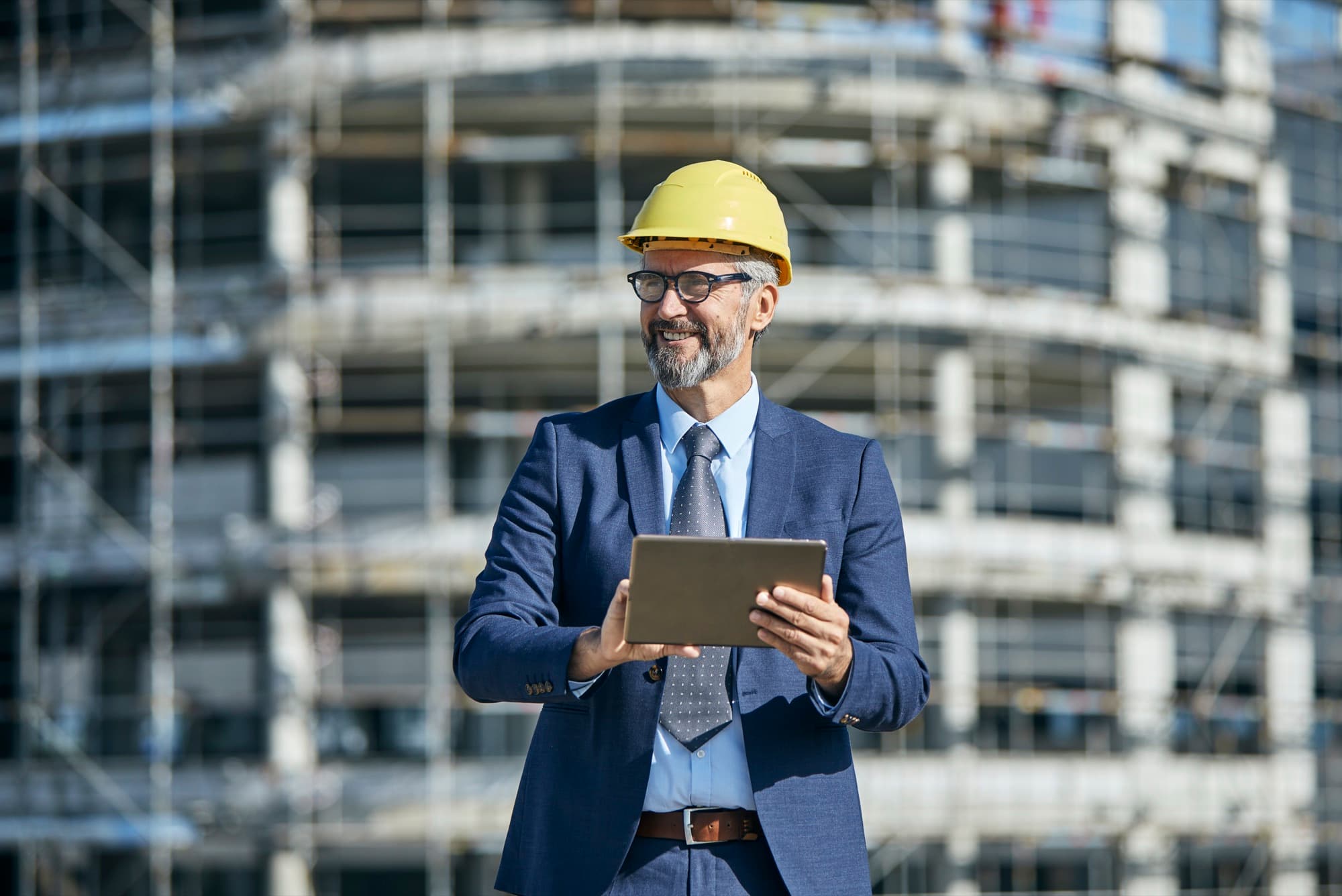 Construction manager resolving a question on a tablet during a site inspection