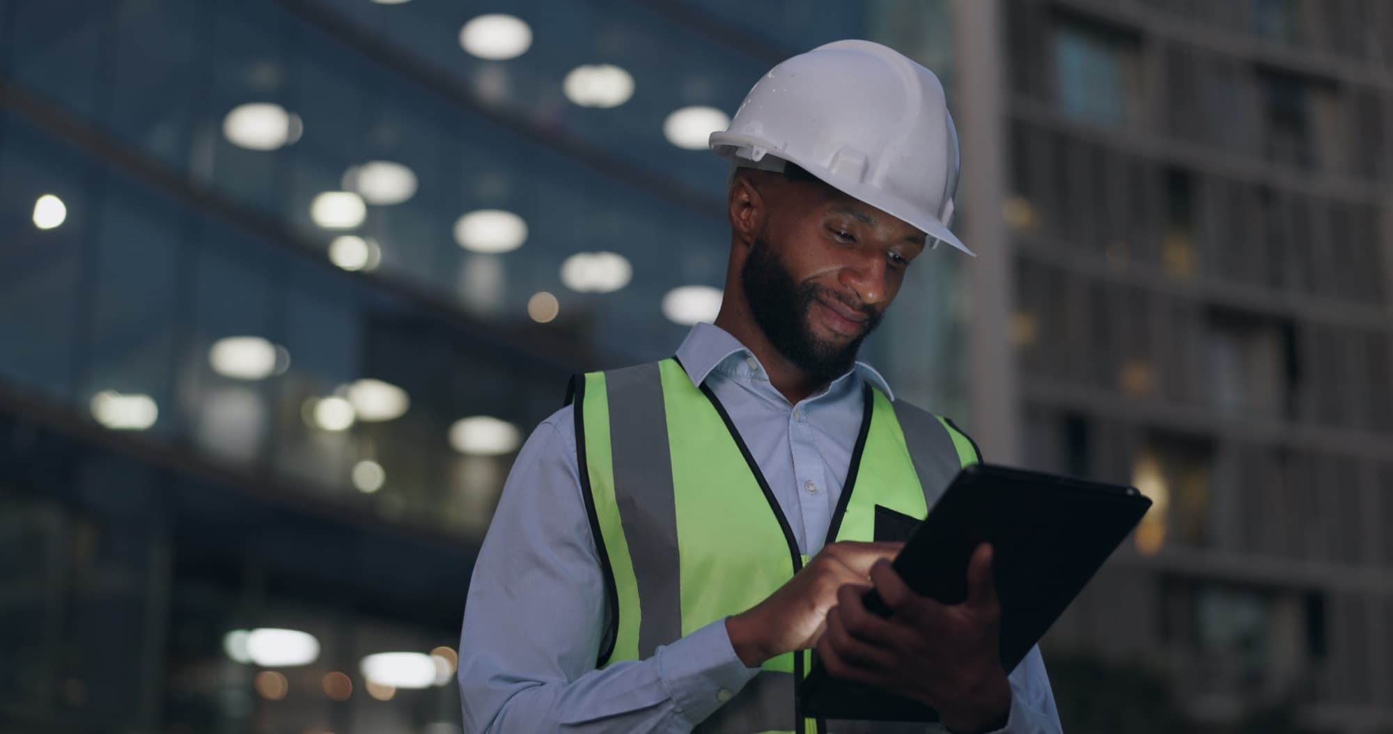 Engineer working on a tablet with a city skyline behind