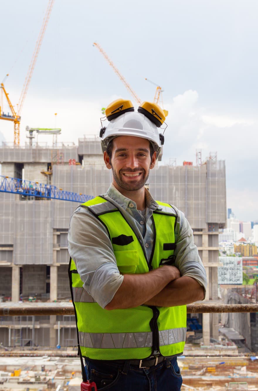Engineer in front of a high-rise under construction with tower cranes
