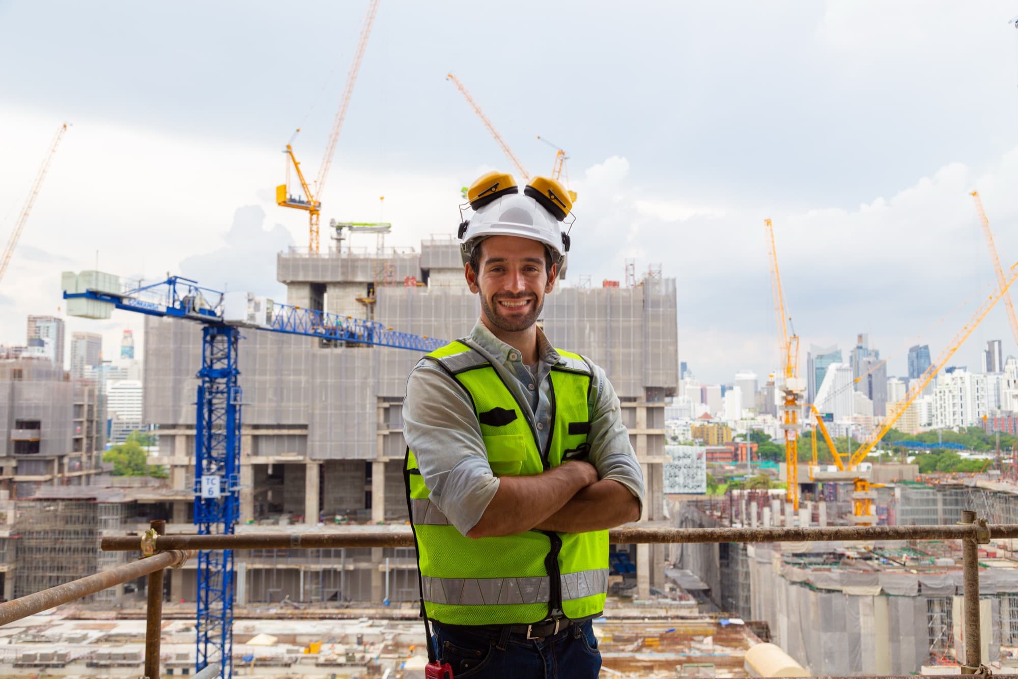 Engineer on a high-rise site with tower cranes in the background