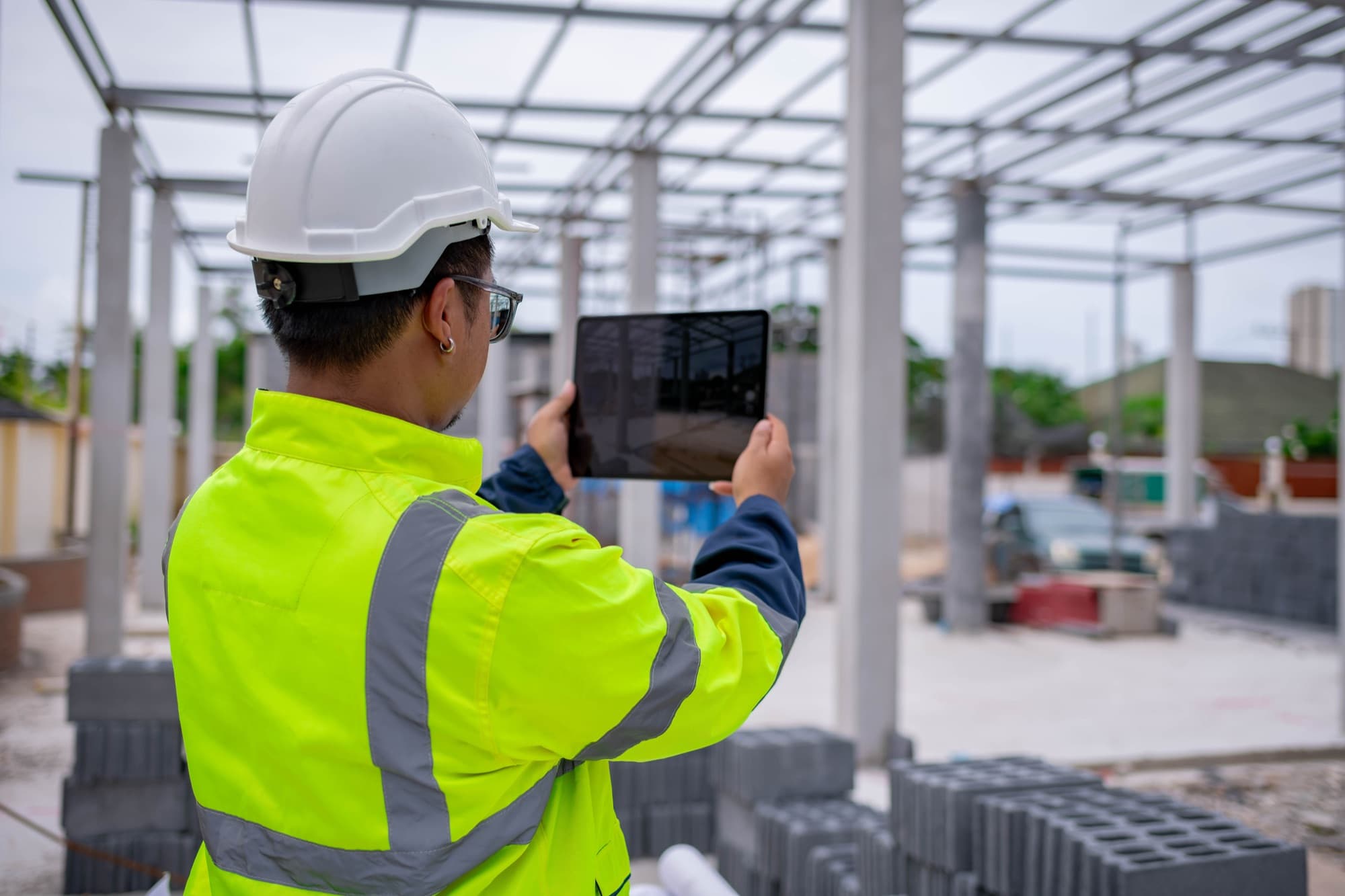 Engineer checking drawings against site conditions on a tablet