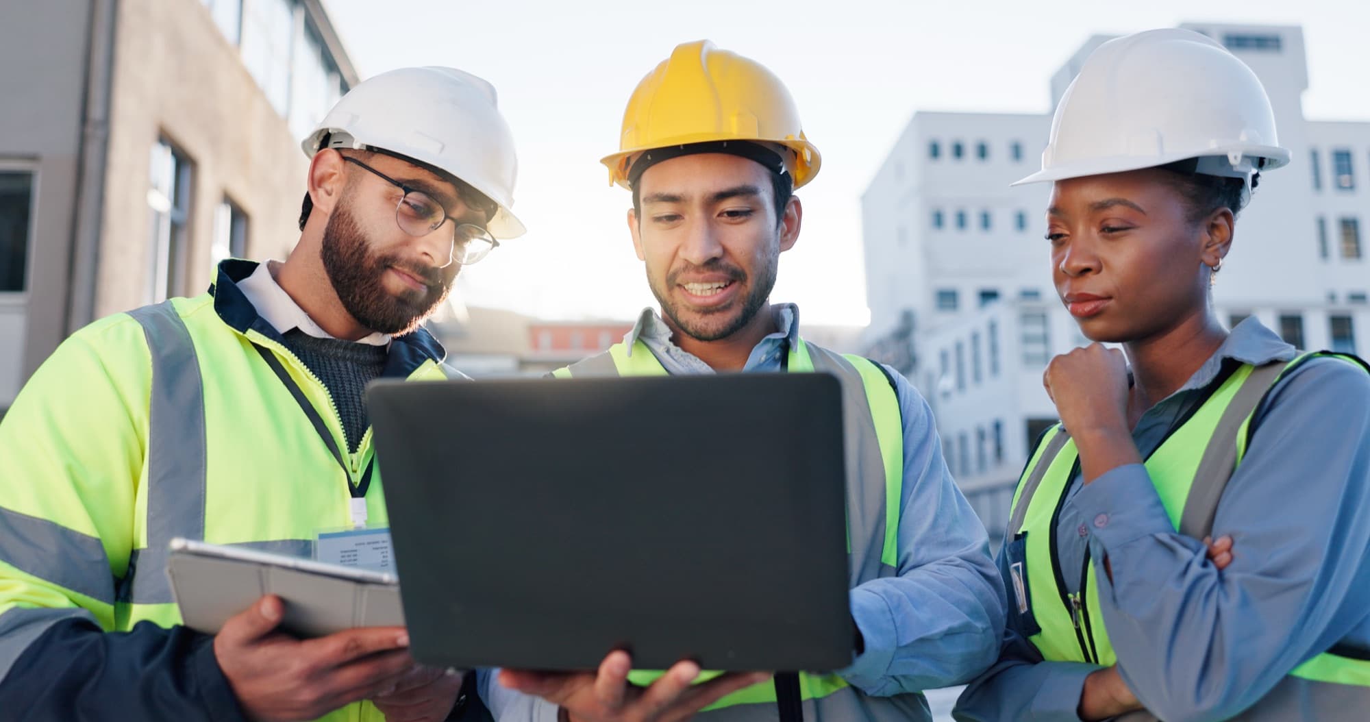 Engineers working through system configuration on a laptop and tablet on site
