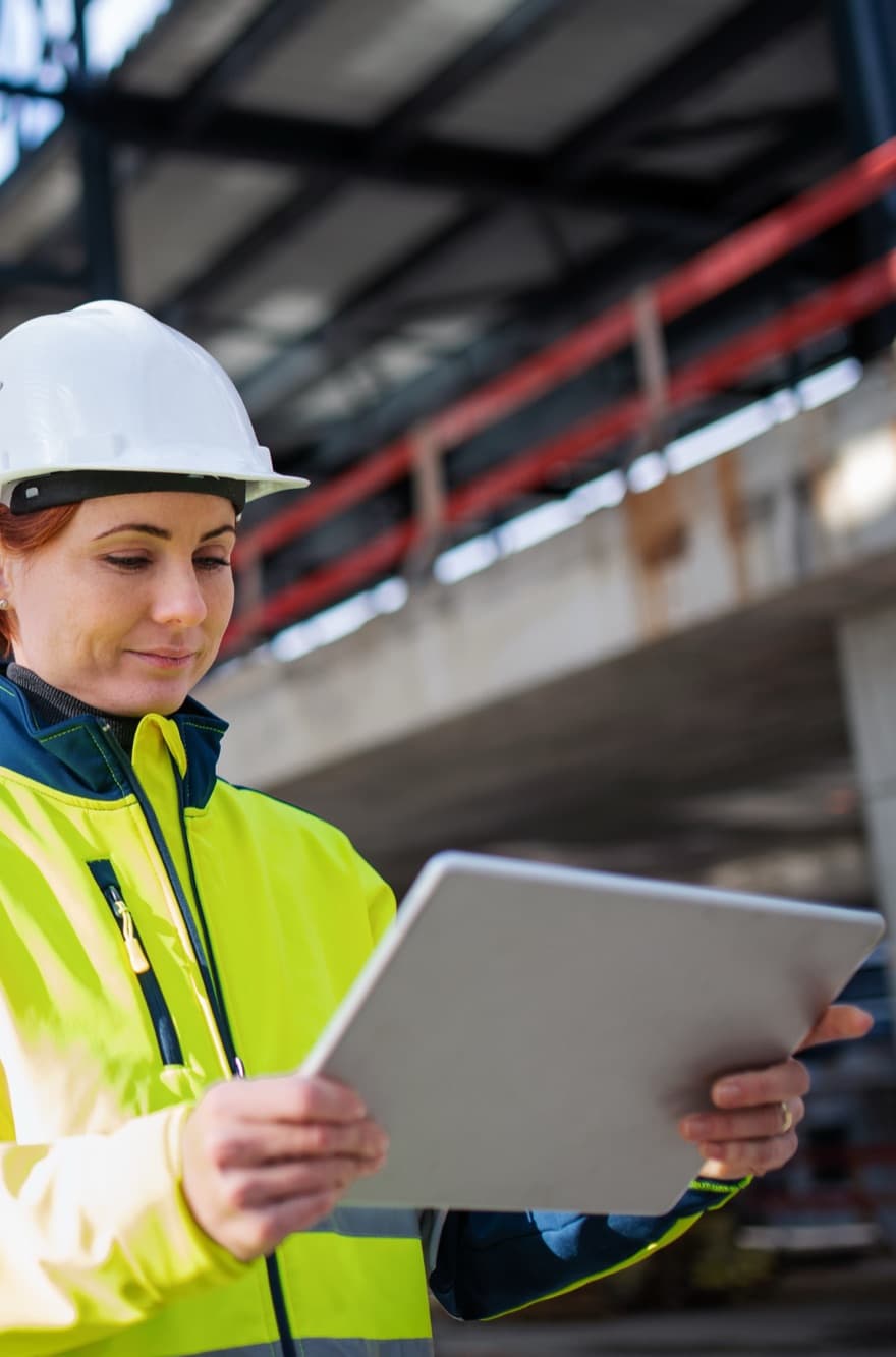 Project manager overseeing a construction site with a tablet