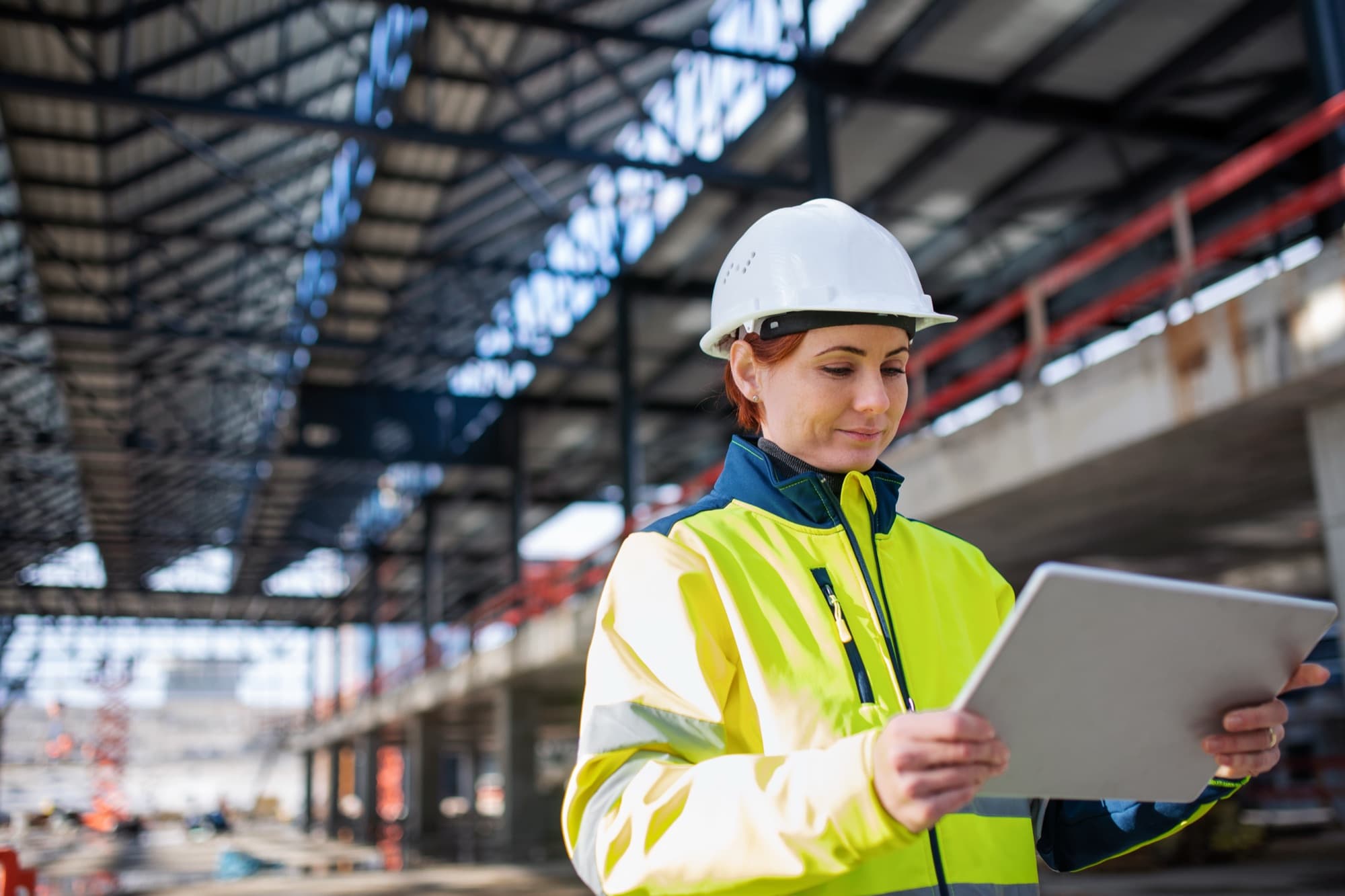 Engineer reading a tablet beneath a concrete structure