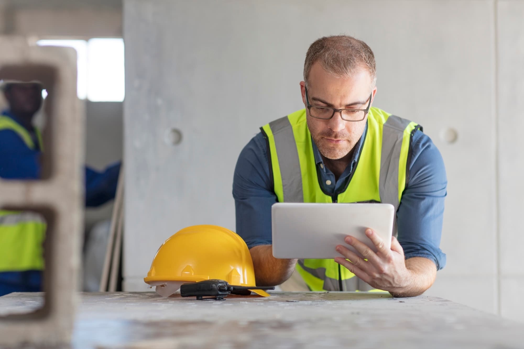 Site manager recording progress on a tablet while walking the site