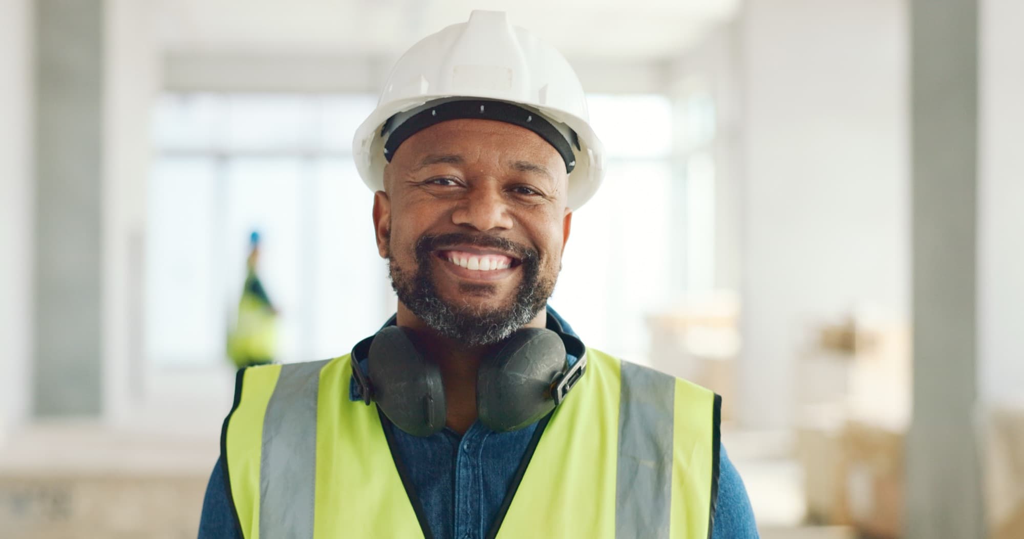 Smiling construction worker with ear defenders around his neck during an interior fit-out