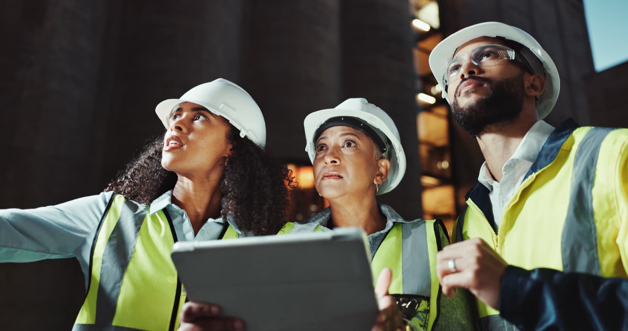 Construction workers checking progress on a tablet at a building site